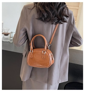 Close-up of brown PU leather Boston bag with silver hardware and adjustable shoulder strap
