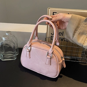 Detail view of pink PU leather Boston handbag with silver D-rings and top zipper closure