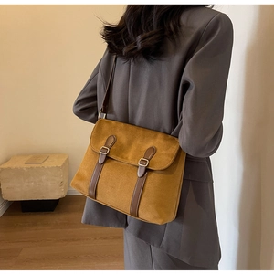Detail view of brown faux suede crossbody bag featuring vintage buckle straps for women