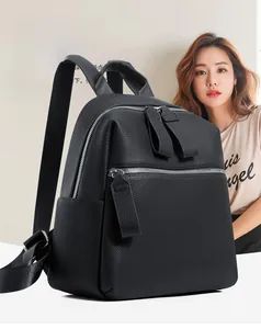 Close-up of black pebble grain leather backpack featuring dual zippers and front pocket