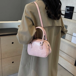 Detail of pink PU leather mini Boston bag with silver hardware and shoulder strap