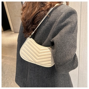 Chic cream-white quilted shoulder bag styled on a grey herringbone suit blazer