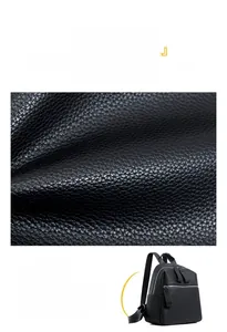 Detailed close-up of premium black lychee texture leather on a stylish waterproof backpack