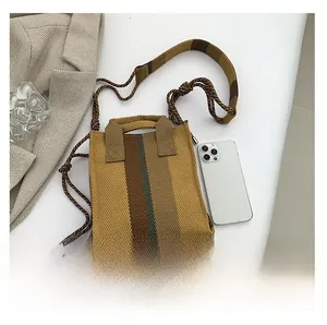 Detail of the striped knitted tote bag with woven rope shoulder strap and dual top handles