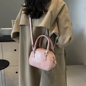 Close-up of pink glossy PU leather Boston bag with silver hardware and detachable strap