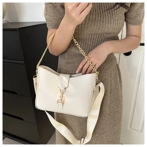On-body view of cream hobo bag with gold piston clasp and adjustable shoulder strap