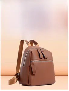 Detail of a brown lychee pattern PU leather backpack with silver zippers and side pockets