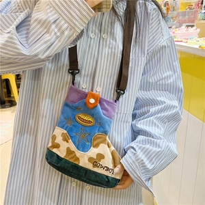 Detail of cowboy boot shaped crossbody bag with cow print and colorful wool texture