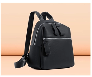 Close-up of black litchi pattern PU leather backpack with silver zippers and side pocket