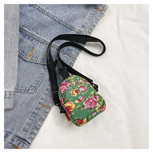 Green floral canvas crossbody bag with vibrant pink flower patterns and black strap