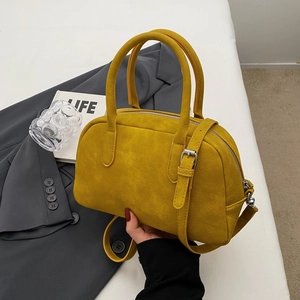 Detailed macro view of the bright yellow faux suede texture and silver hardware on handbag