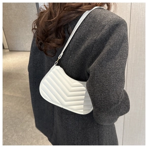 Detail of white quilted underarm bag with V-shaped stitching and matte leather finish