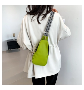 Borsa pettorale verde lime in pelle martellata con tracolla geometrica sul modello