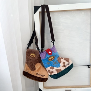 Detailed view of plush cowboy boot shaped crossbody bags with star embroidery