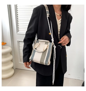 Detail of striped canvas tote bag with woven rope strap and minimalist design