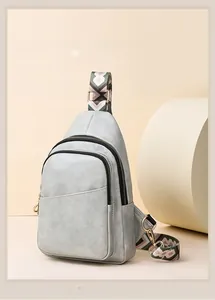 Détail du sac bandoulière en cuir de vachette gris clair avec sangle tissée et dorures