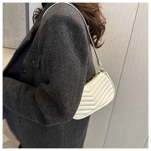 White quilted faux leather underarm bag worn with a stylish dark grey herringbone coat