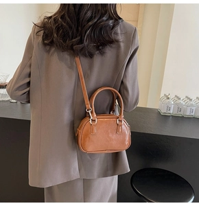 Rear view of a model wearing the brown vintage semi-circular PU crossbody bag