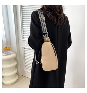 Dettaglio borsa a tracolla beige in pelle PU con cinturino geometrico intrecciato bianco e nero