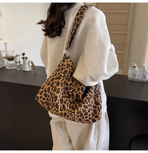 Détail de la texture en tissu léopard et du bouton noir sur le sac à bandoulière tendance