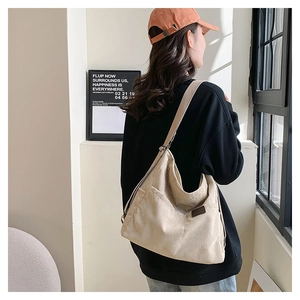 Détail du sac bandoulière en velours côtelé beige avec poche latérale et logo épuré