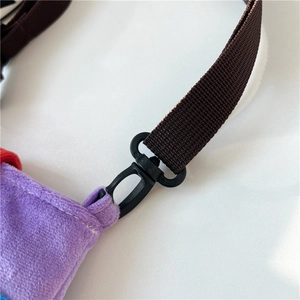 Macro detail of purple fleece fabric bag with brown nylon strap and black plastic hook