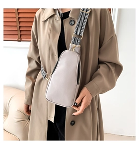 Dettaglio borsa pettorale in PU beige con texture litchi e tracolla geometrica