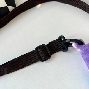 Detail of dark brown nylon strap with black plastic buckle on purple fuzzy wool bag