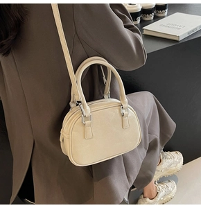 Detail of cream vintage Boston bag with glossy PU leather and silver zipper hardware