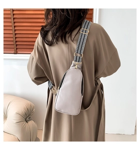Dettaglio borsa da petto in pelle PU grigio chiaro con tracolla tessuta e fibbie oro