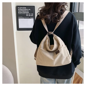 Détail de la texture en velours côtelé beige du sac à dos avec poche et bretelles