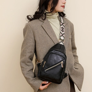 Detail of black crossbody bag with a wide geometric patterned ethnic shoulder strap