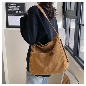 Détail du sac cabas en velours côtelé marron avec poche avant et bandoulière réglable