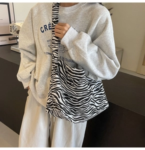 Gros plan détaillé du grand sac cabas en toile à motif zèbre noir et blanc avec large bandoulière