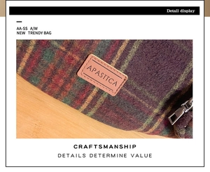 Detail view of purple plaid wool fabric texture and brown leather logo on the bag