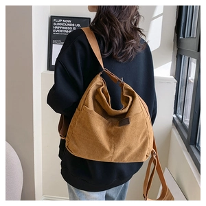 Détail du sac fourre-tout en velours côtelé marron avec texture côtelée et logo cuir
