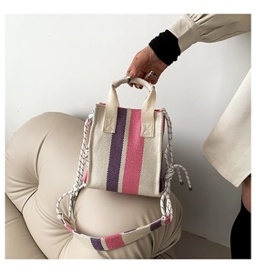 Detail of the woven texture and color stripes on the stylish handbag with rope strap
