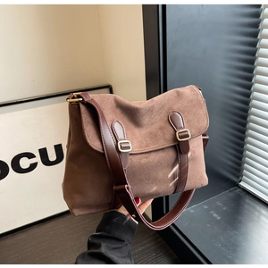 Brown velvet shoulder bag with leather straps and gold buckle in a minimalist winter style
