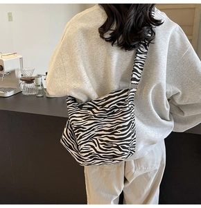 Détail du sac bandoulière en toile à motif zèbre avec grande capacité et sangle réglable