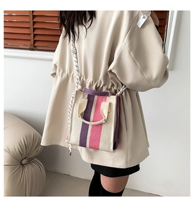 Detail of compact striped canvas tote bag with woven rope shoulder strap for women