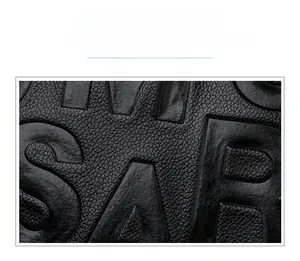 Détail d'un sac à main noir montrant le grain du cuir et les lettres gaufrées élégantes