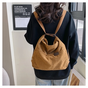 Détail du sac à dos en velours côtelé marron montrant la texture côtelée et le logo