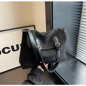 Minimalist black velvet crossbody bag with gold hardware shown in a modern home setting