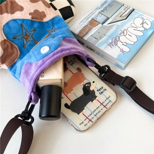 Detail of plush crossbody bag showing inner storage capacity for phone and cosmetics