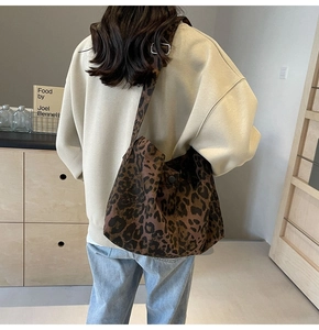 Vue détaillée du sac hobo en toile léopard montrant le drapé et la large bandoulière
