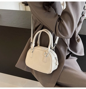 Chic cream white crescent handbag styled with a deep brown blazer for a trendy look