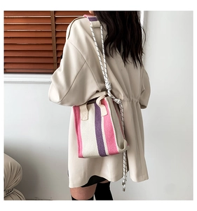 Detail view of pink and purple striped canvas tote bag with woven rope shoulder strap