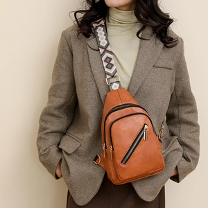 Brown PU leather crossbody bag with geometric jacquard strap shown on model shoulder