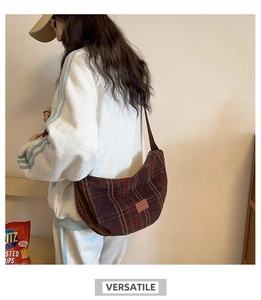 Detail view of retro plaid hobo bag made of tweed fabric worn by model in casual outfit