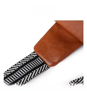 Detail of precise stitching on brown lychee grain leather and geometric fabric shoulder strap